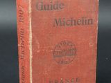 an old red book sitting on top of a black table