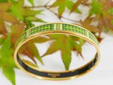 a close up of a bracelet with green and yellow squares on it