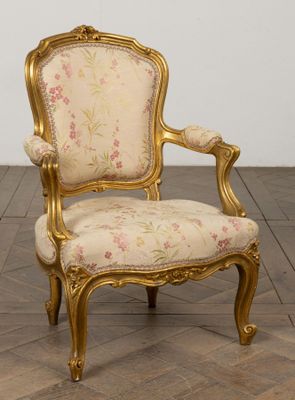 une image représentant une chaise dorée dont l'assise est recouverte d'un tissu à motifs floraux