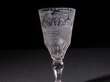 a wine glass sitting on a table with a black background