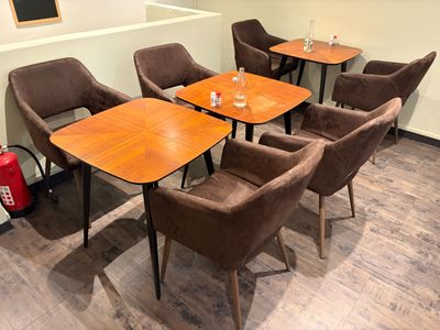 tables and chairs in a room with a fire extinguisher in the background
