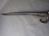 a very long knife that is laying on a table