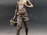 bronze statue of a boy with a bucket and a hat