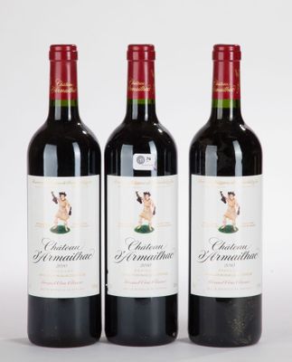 trois bouteilles de vin rouge posées l'une à côté de l'autre sur une surface blanche