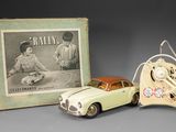 a small toy car next to a picture of a man