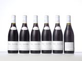 six bottles of wine lined up in a row on a table