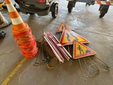 a pile of traffic signs and a traffic cone on the ground