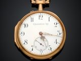 gros plan d'une montre de poche en or sur une surface noire