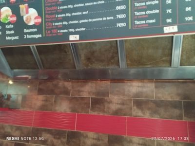 a menu on the wall of a restaurant with a red stripe