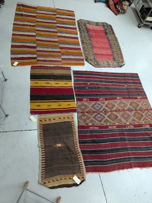 several different rugs are laid out on the floor in a room