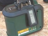 a green and black device sitting on top of a piece of plywood