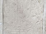 une image représentant une plaque de pierre sur laquelle est sculpté un bateau