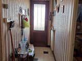 a hallway with a door, a mirror, and a chair in it