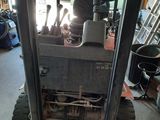 a forklift in a garage with a lot of tools on it