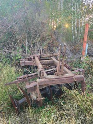 une charrue rouillée abandonnée au milieu d'un champ