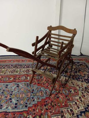 une petite chaise en bois posée sur un tapis posé à même le sol