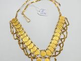 a gold necklace with coins and chains on a white background
