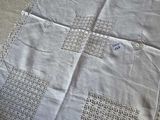 an image of a white table cloth with a cross stitch design on it