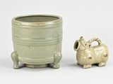 a small ceramic animal next to a pot on a table