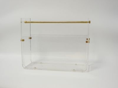 a clear acrylic magazine holder with gold handles