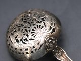 a silver spoon with a decorative design on it