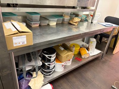 de nombreux récipients contenant de la nourriture sur une étagère métallique dans la cuisine