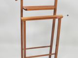 a wooden coat rack with a coat hanger on it