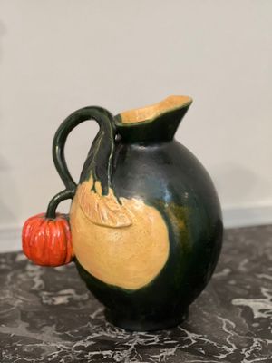 a black vase with a yellow and orange decoration on it