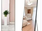 un miroir posé au sol à côté d'une plante