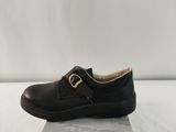 black leather shoes with buckles and a box on a white surface