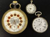 trois types différents de montres de poche posées sur une surface noire