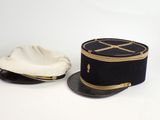 pair of black and white hats with gold trims on a white surface