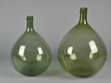 pair of green glass vases sitting on top of a gray surface