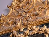 a mirror with a gold frame and a mirror with a bird on it