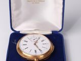 a gold pocket watch in a blue case on a table