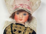 a doll that is wearing a hat and a dress
