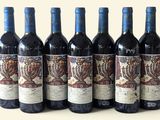 six bouteilles de vin sont alignées sur une table