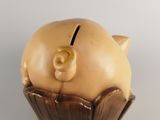 a piggy bank in a chocolate cupcake on a white surface