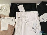 three pairs of pants and a shirt on a shelf