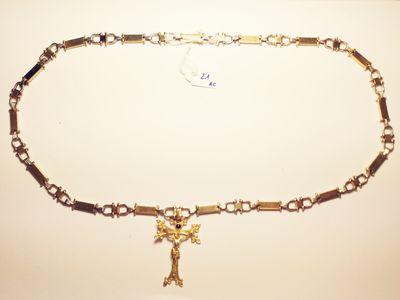 a gold chain with a cross on it on a table