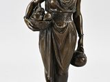 statue en bronze représentant une femme tenant un panier de fleurs, posée sur un socle