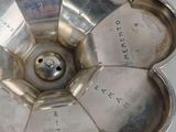 a silver flower shaped bowl with writing on it