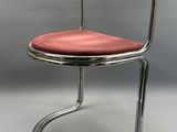 une chaise rouge avec une structure chromée et un coussin rouge