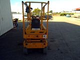 a small yellow lift truck parked in a parking lot