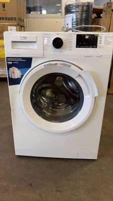 white washing machine in a store with boxes and boxes in the background
