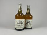two bottles of beer sitting next to each other on a white surface