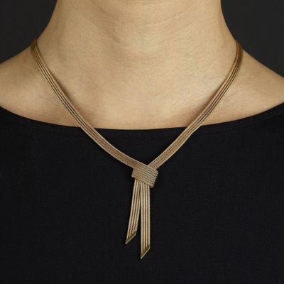 une femme portant un collier en or et un haut noir