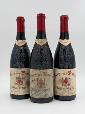 three bottles of wine are lined up on a white surface