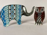two figurines of an elephant and an owl on a table