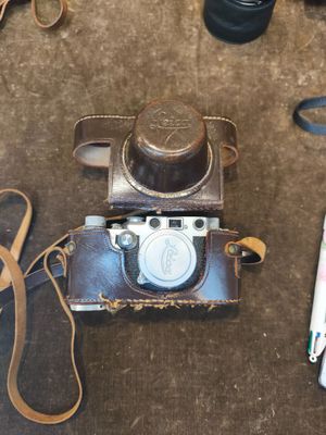 un appareil photo, un téléphone portable et un étui pour appareil photo posés par terre